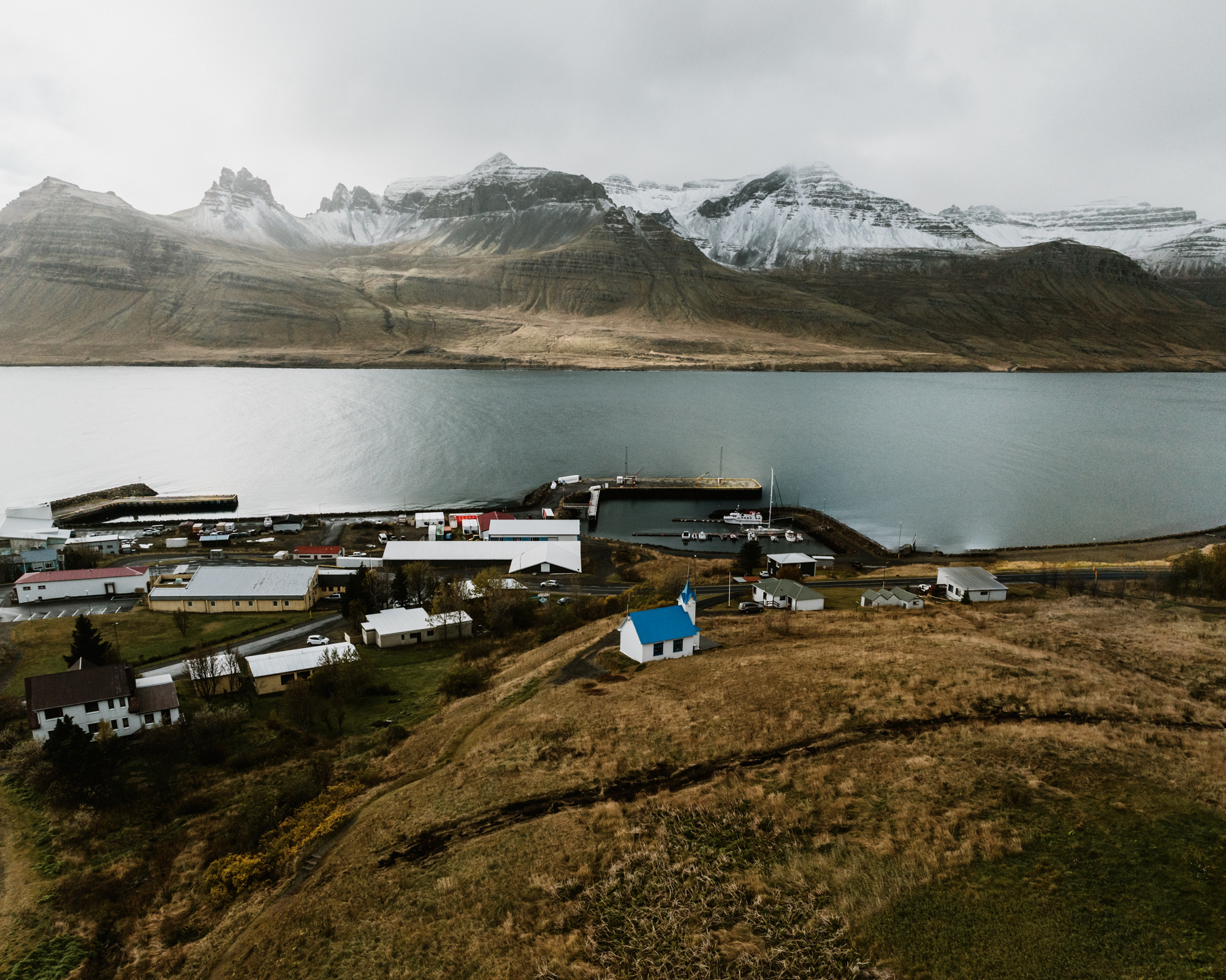 Tiny Church below a wide fjord and snow-dusted mountains