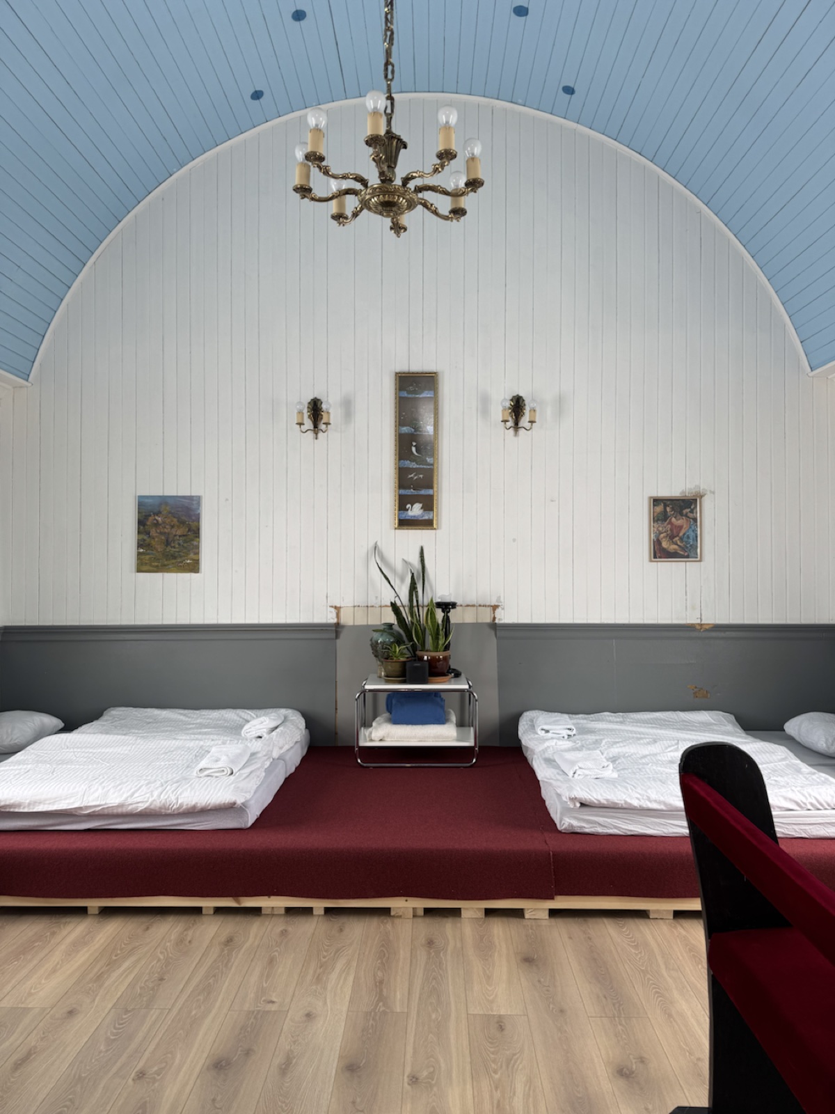 Beds under the old church wall and chandelier